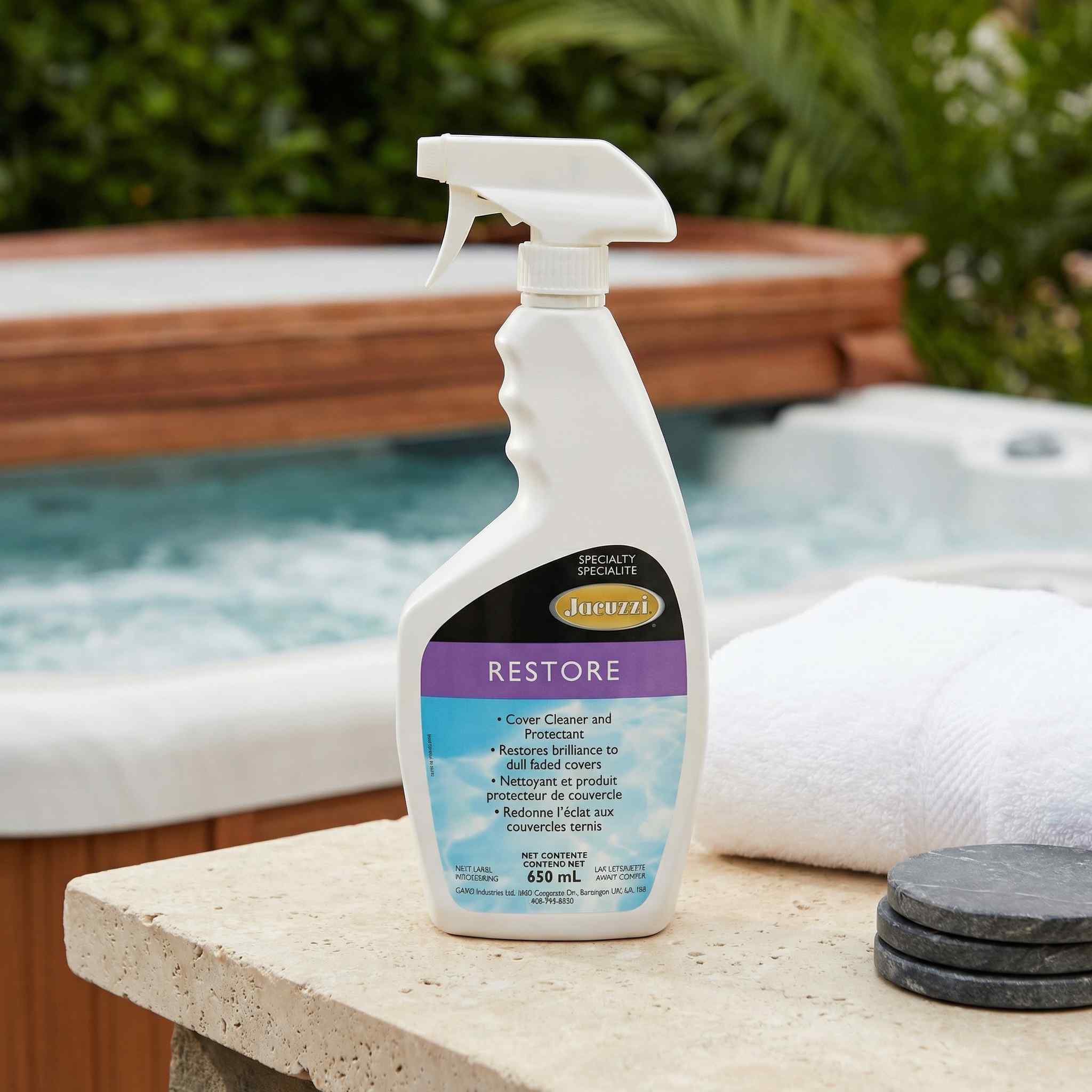 Spray bottle labeled 'Restore' by Jacuzzi on a ledge with a hot tub in the background.