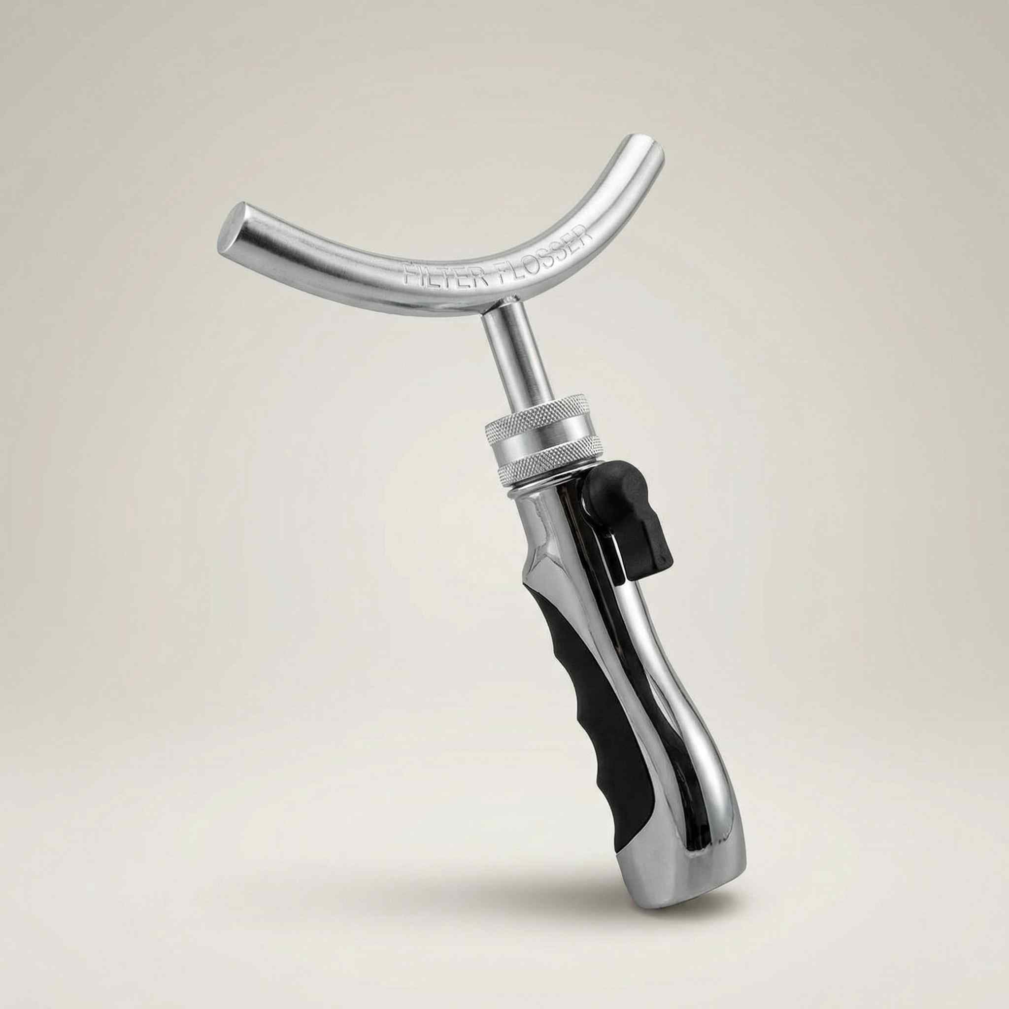 Metal tool with a black handle on a beige background
