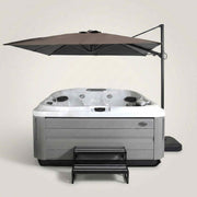 Jacuzzi® Umbrella Articulating Square Sienna shading a Jacuzzi hot tub on a patio with outdoor lounge furniture