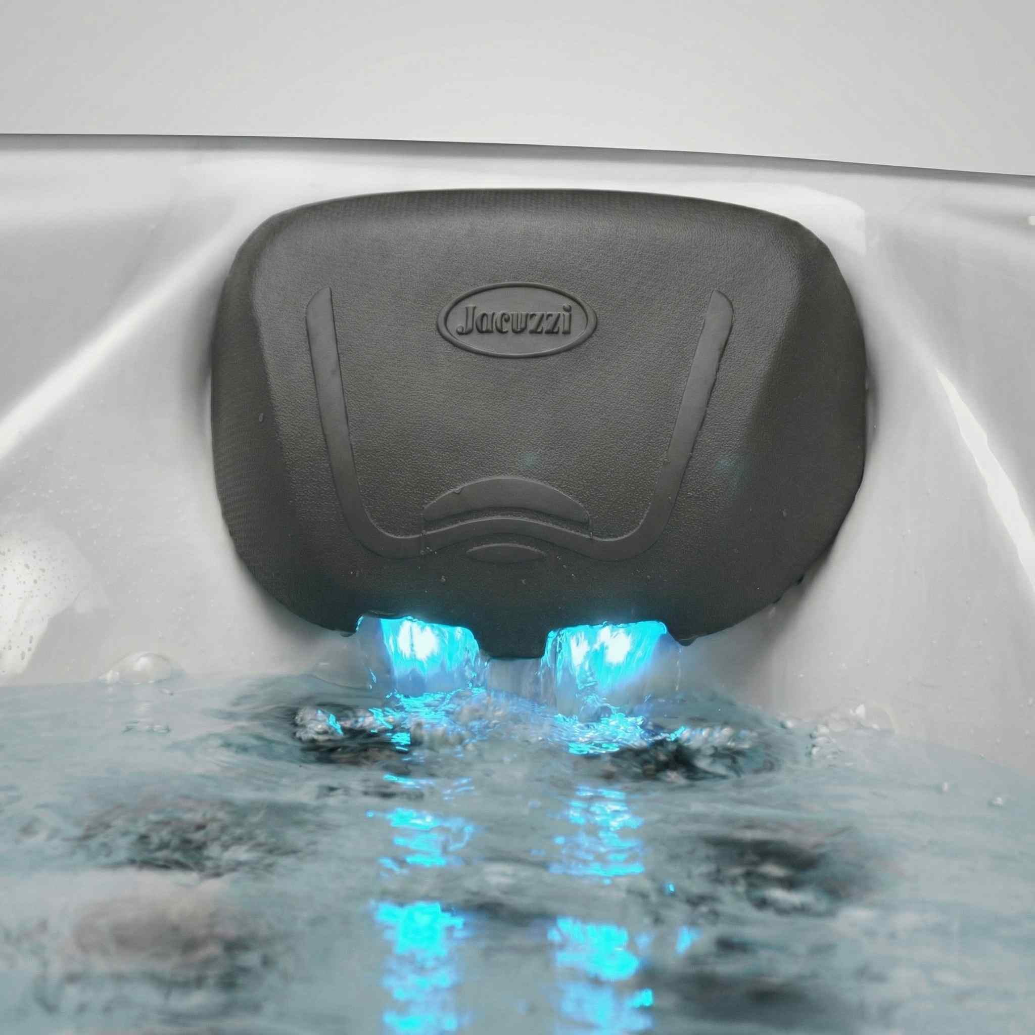 Jacuzzi® Pillow Hydrosoothe Kit installed on a hot tub with glowing blue LED lights and water cascading down