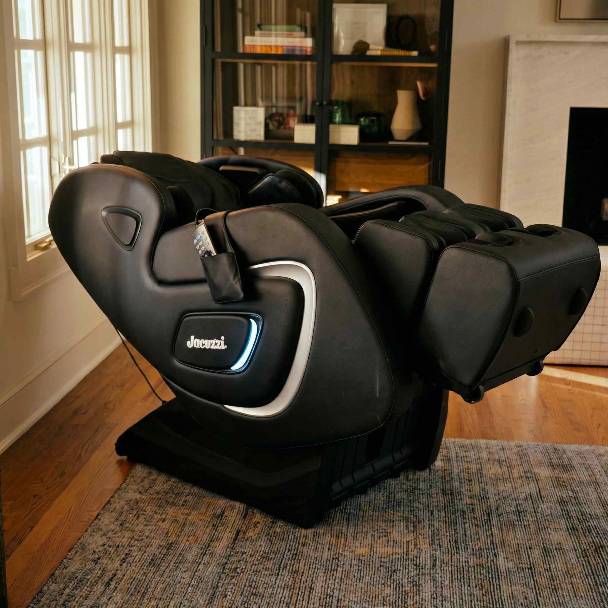 Black massage chair in a room with a bookshelf and window