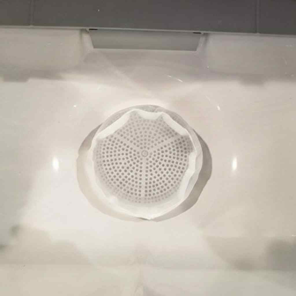 Filter debris trap installed inside a hot tub skimmer basket viewed through the water surface