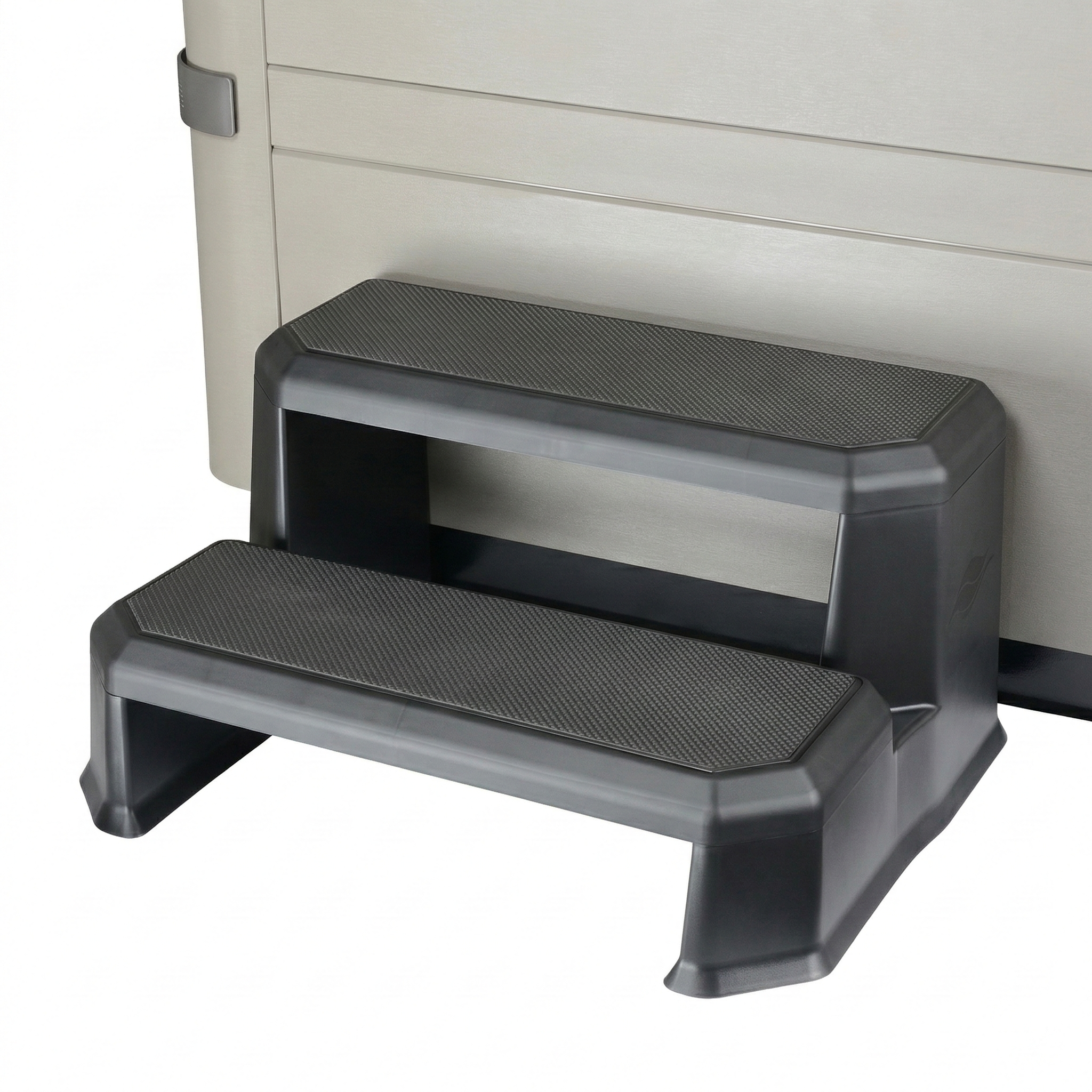 Step stool with textured surface against a hot tub.